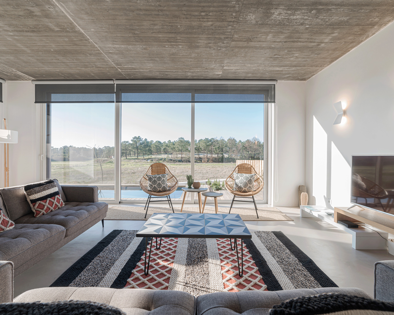 Modern villa living room couch with pool and deck views